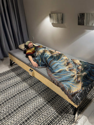 A baltic birch Crescendo Daybed with a listener in a wellness setting