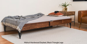 A walnut hardwood Crescendo Daybed in a living room